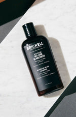 Brickell men's anti-aging gel moisturizer bottle on white marble slab with grey background